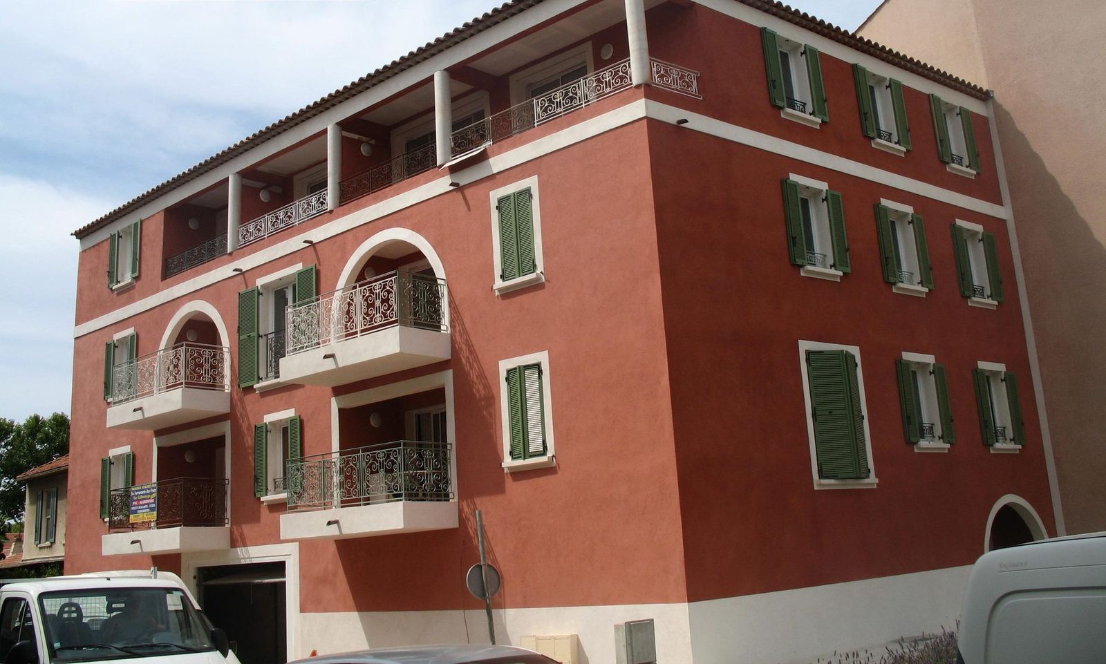 Immeuble Terre de Sienne, façade rouge sienne et volets verts